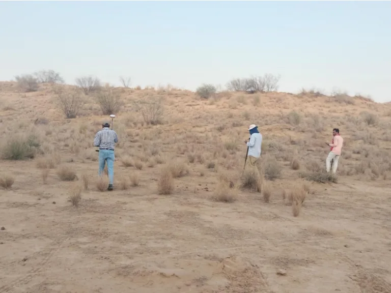Survey team walking a scrub land parcel being assessed for solar feasibility